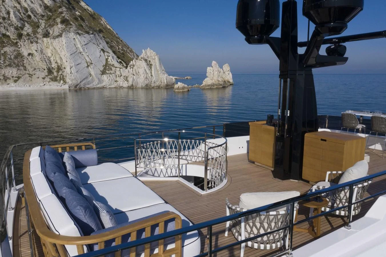 a deck with chairs and a body of water in the background aboard UPSTREAM Yacht for Sale