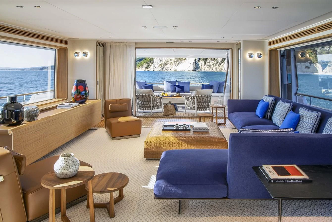 a living room with blue couches aboard UPSTREAM Yacht for Sale