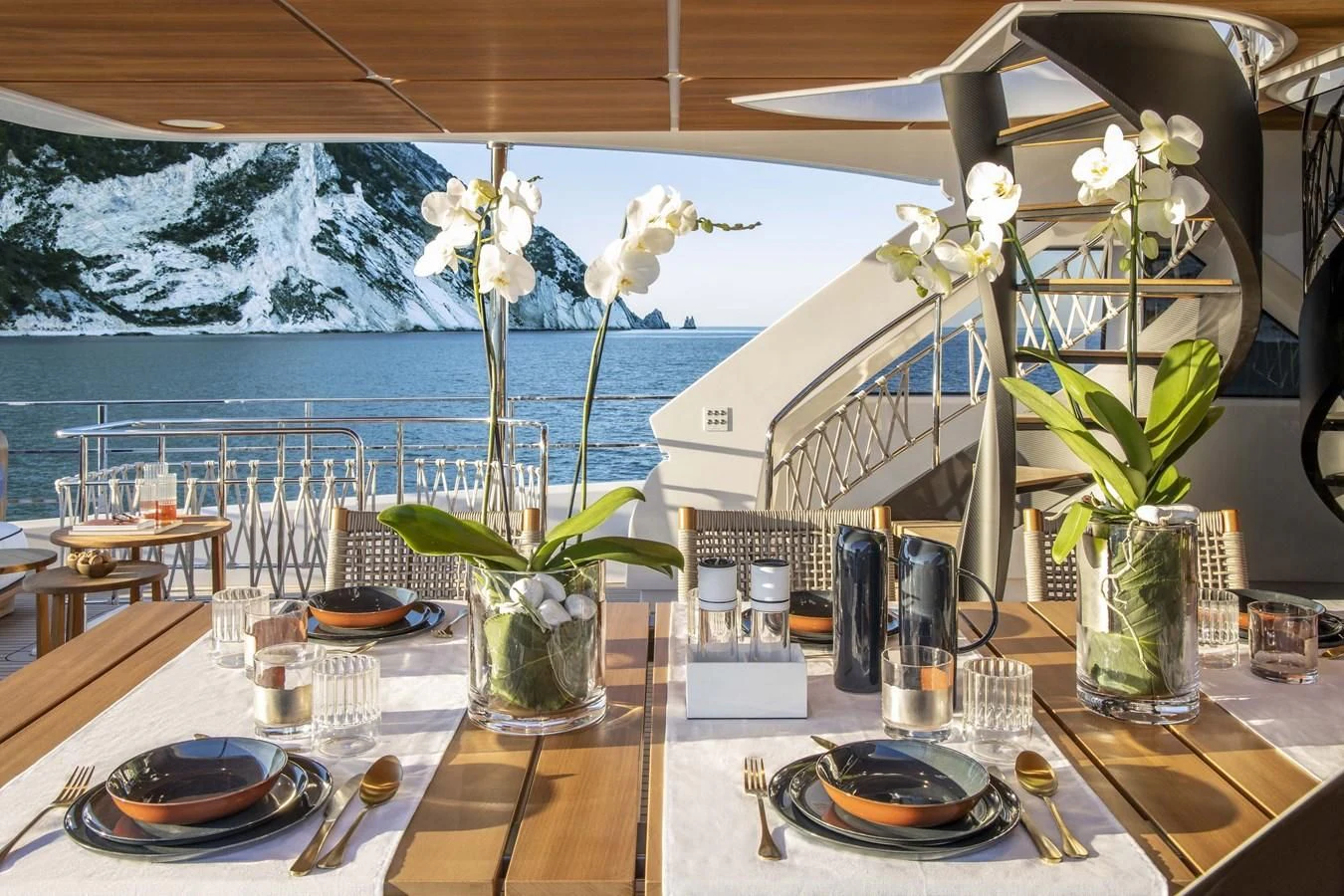 a table with plates and flowers aboard UPSTREAM Yacht for Sale