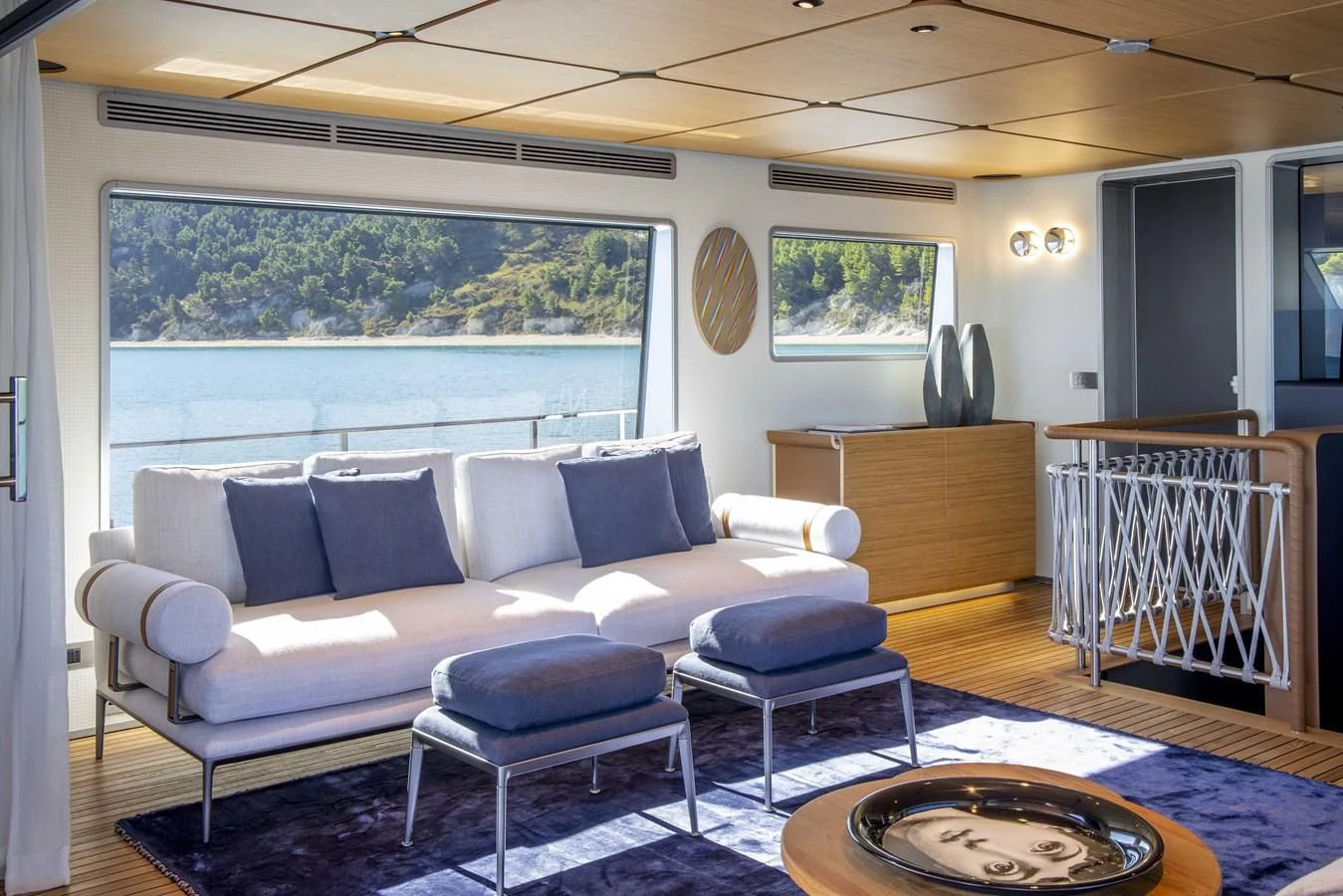 a living room with a blue couch aboard UPSTREAM Yacht for Sale