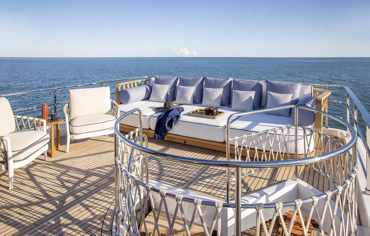 a bed and chairs on a deck aboard UPSTREAM Yacht for Sale
