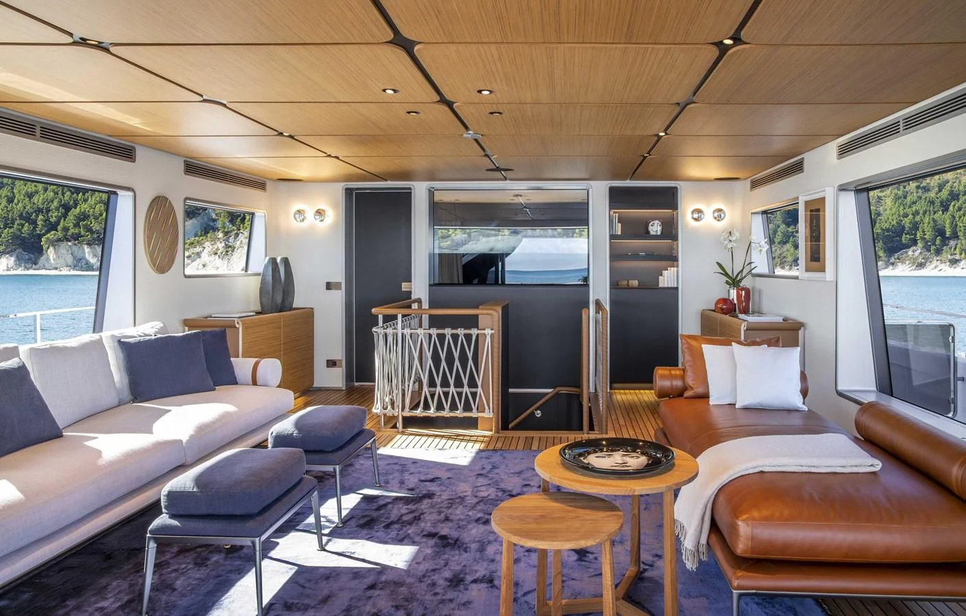 a living room with a blue rug aboard UPSTREAM Yacht for Sale