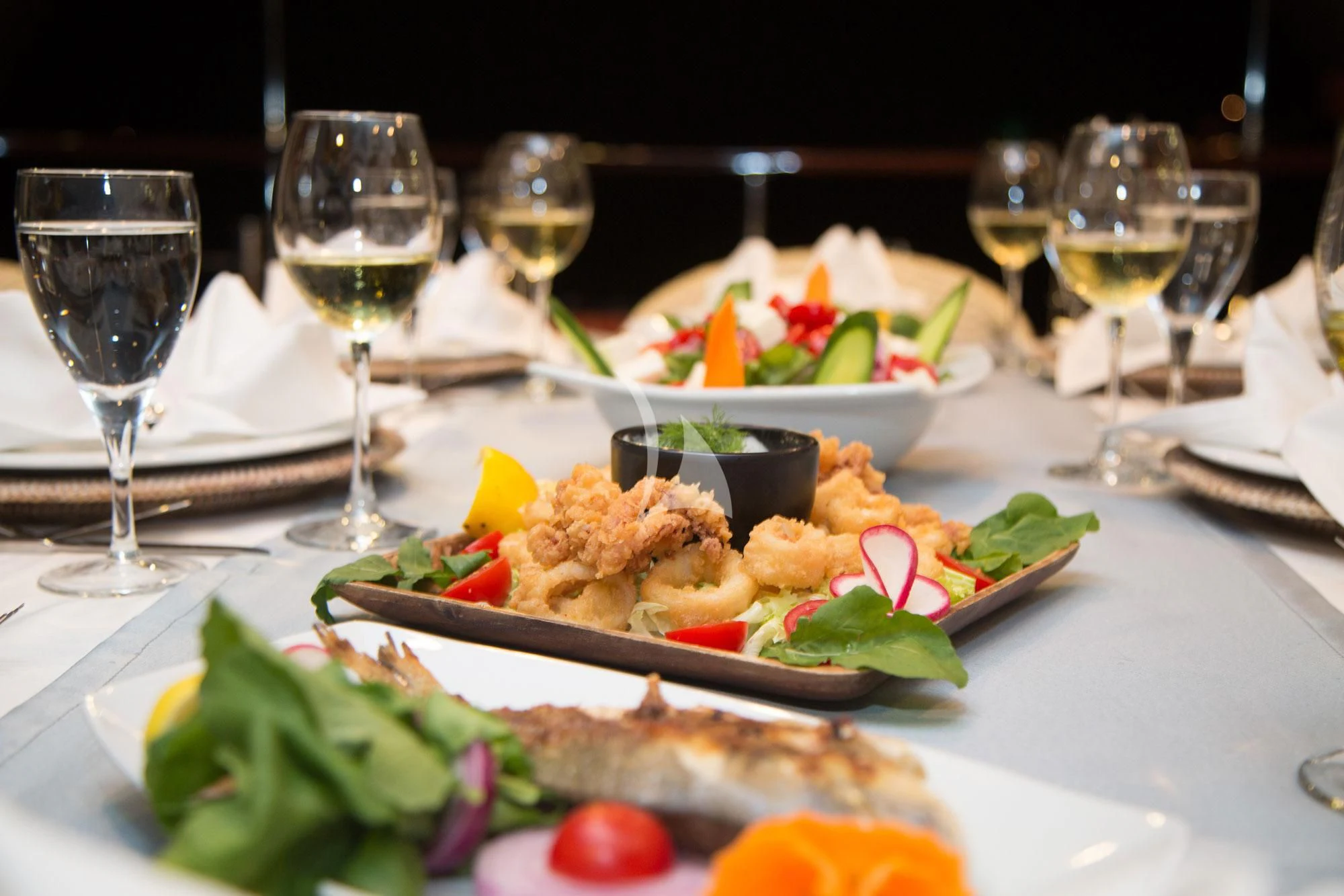 a plate of food and wine aboard SERENITY 86 Yacht for Charter