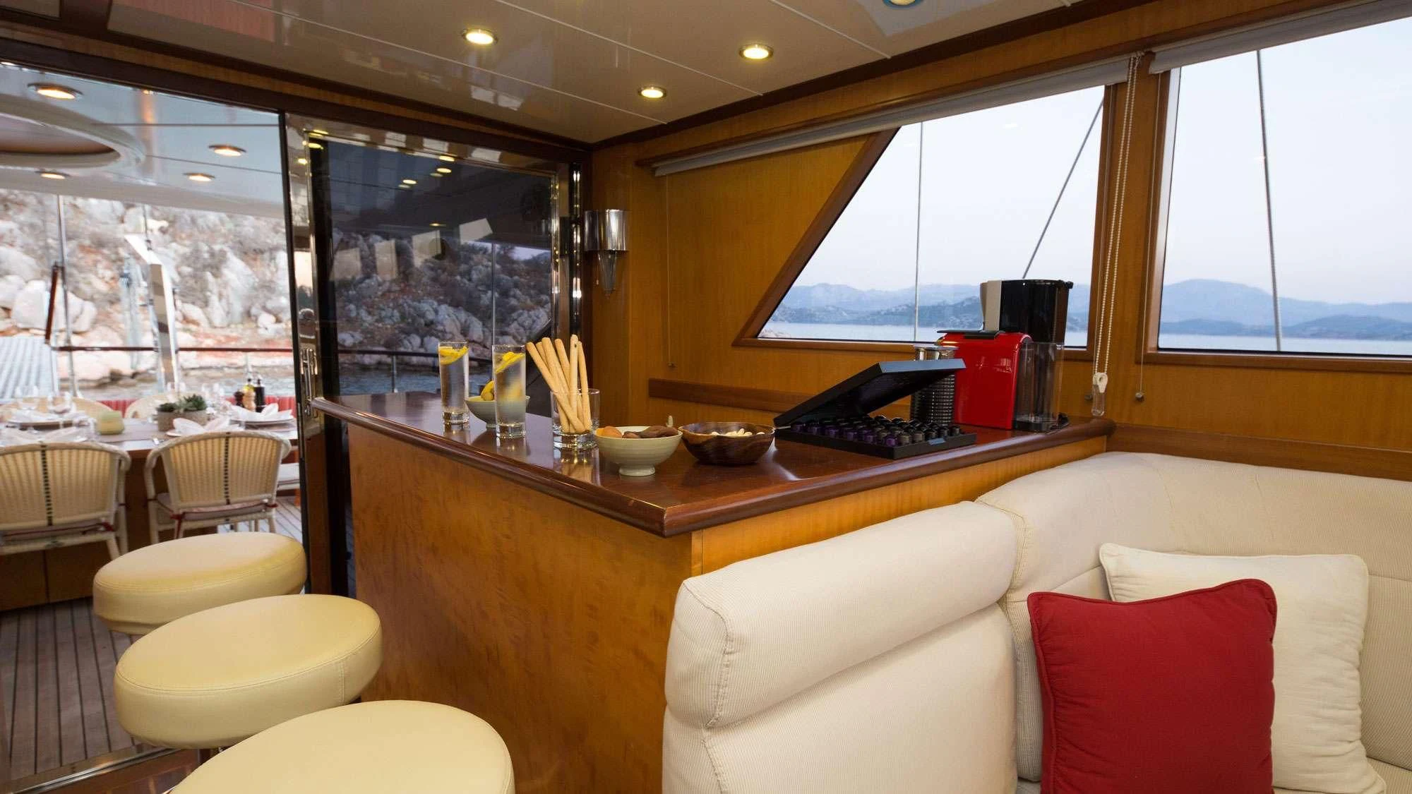 a room with a couch and a table with a laptop on it aboard SERENITY 86 Yacht for Charter