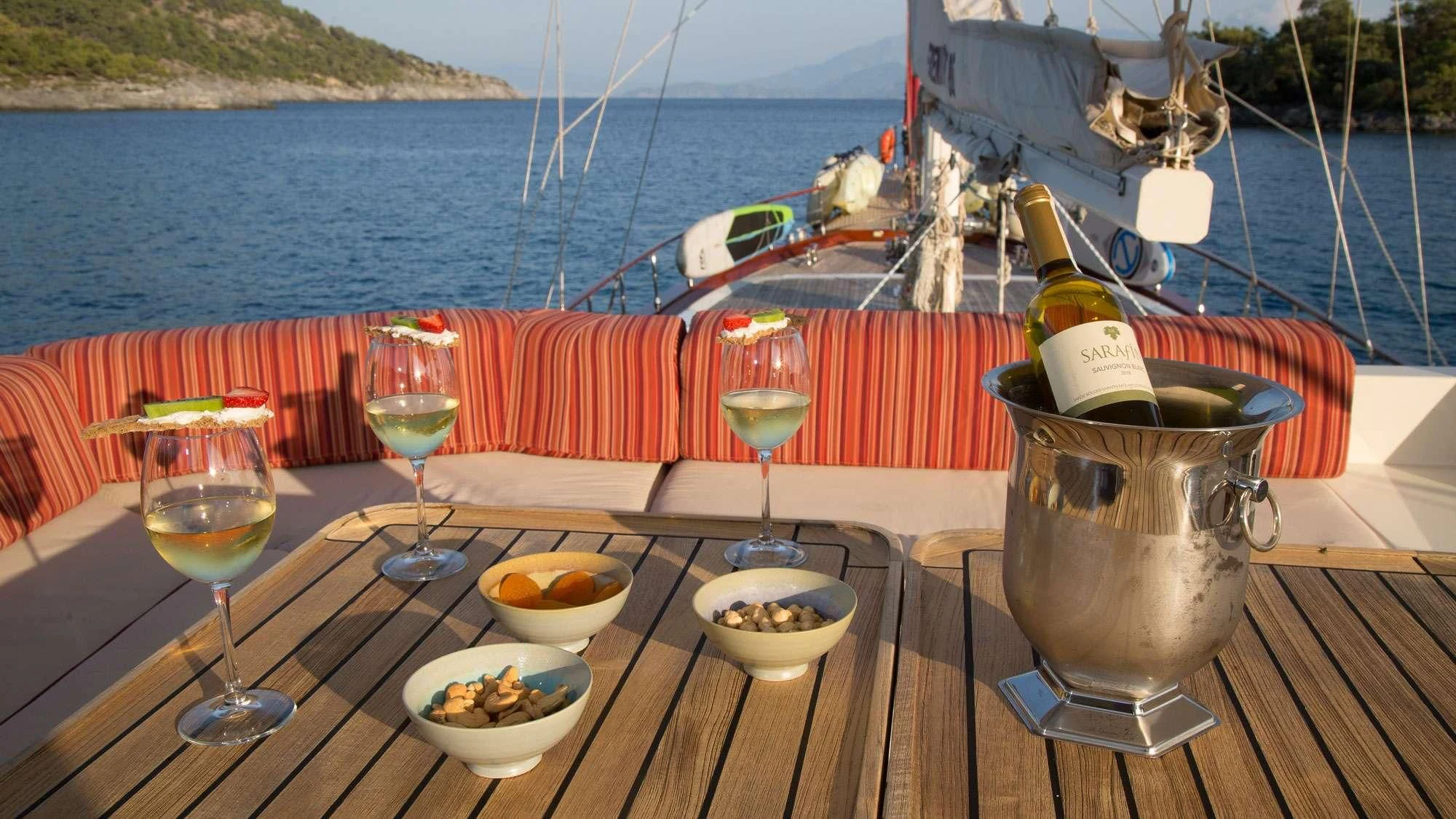 a table with food and drinks on it by a boat aboard SERENITY 86 Yacht for Charter