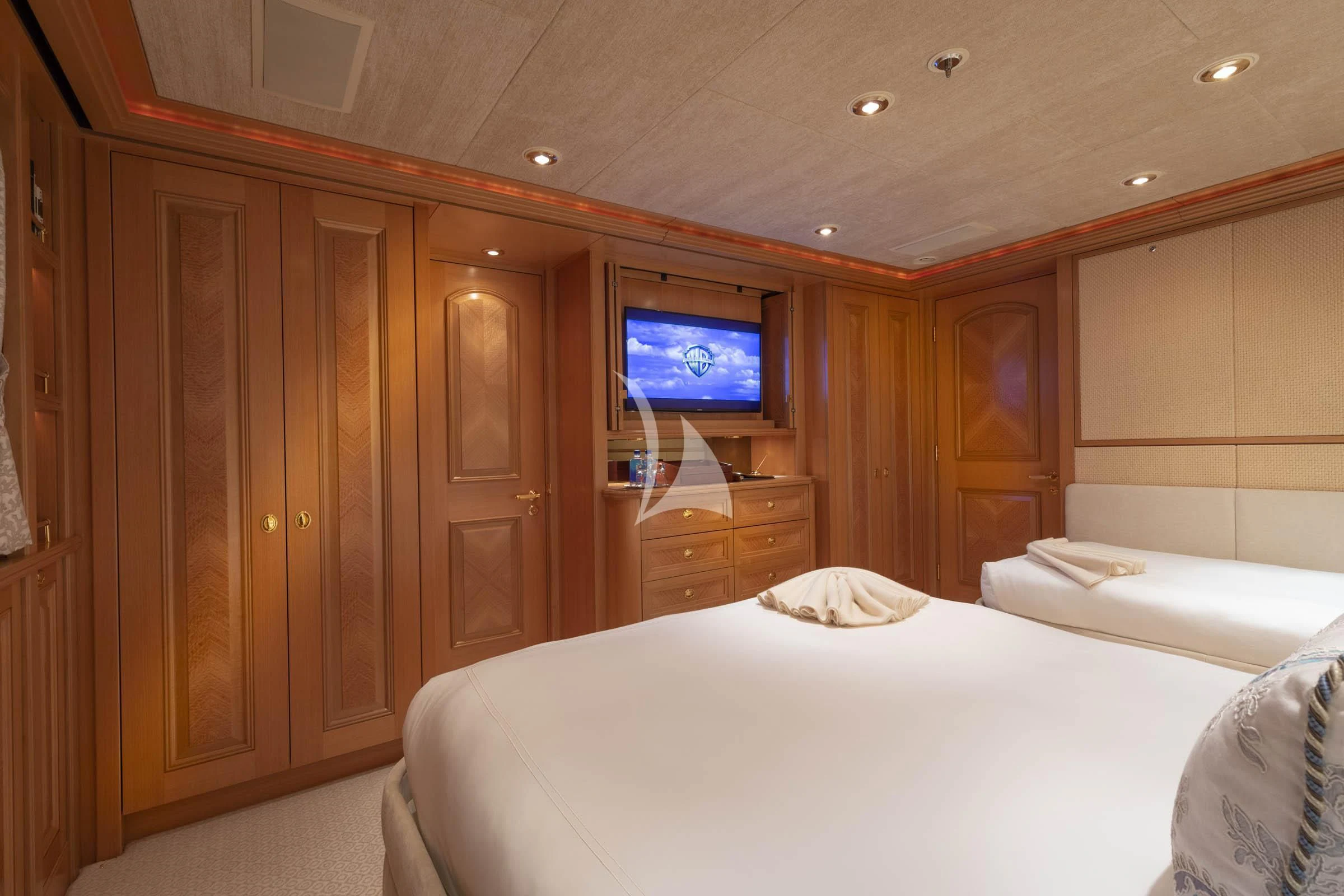 a room with a bed and a television aboard LAUREL Yacht for Charter