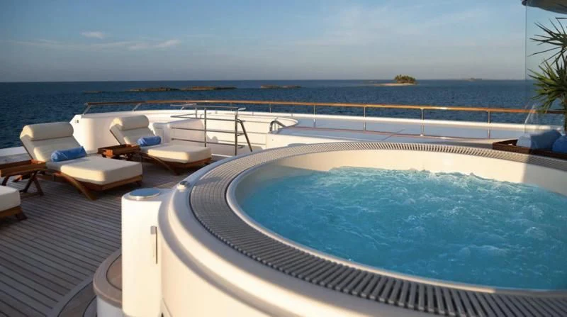 a swimming pool with a deck and lounge chairs and a large body of water aboard LAUREL Yacht for Charter