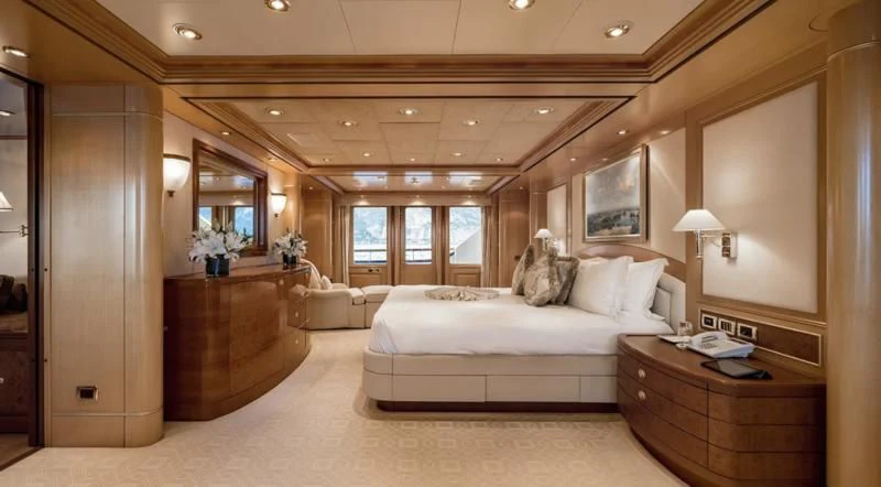 a bedroom with a bed and a dresser aboard LAUREL Yacht for Charter