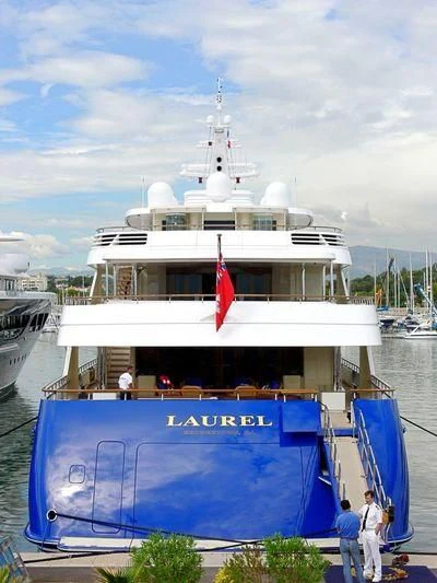a large white boat with a red flag on it aboard LAUREL Yacht for Charter