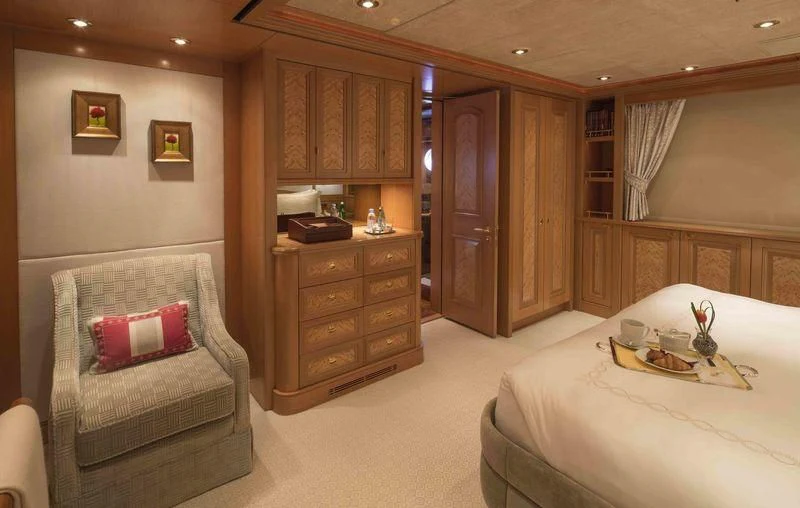 a bedroom with a bed and a chair aboard LAUREL Yacht for Charter