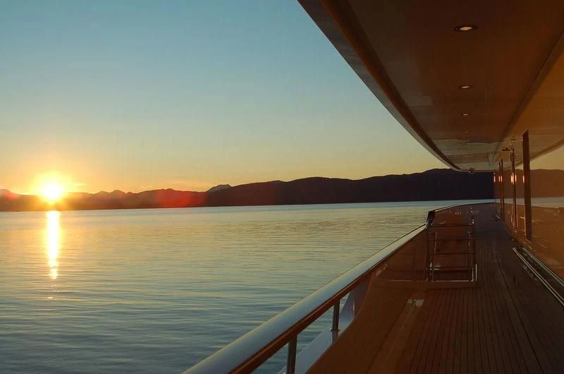 a dock leading to a body of water with a sunset in the background aboard LAUREL Yacht for Charter