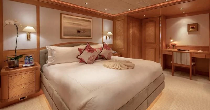 a bed with white sheets and pillows aboard LAUREL Yacht for Charter