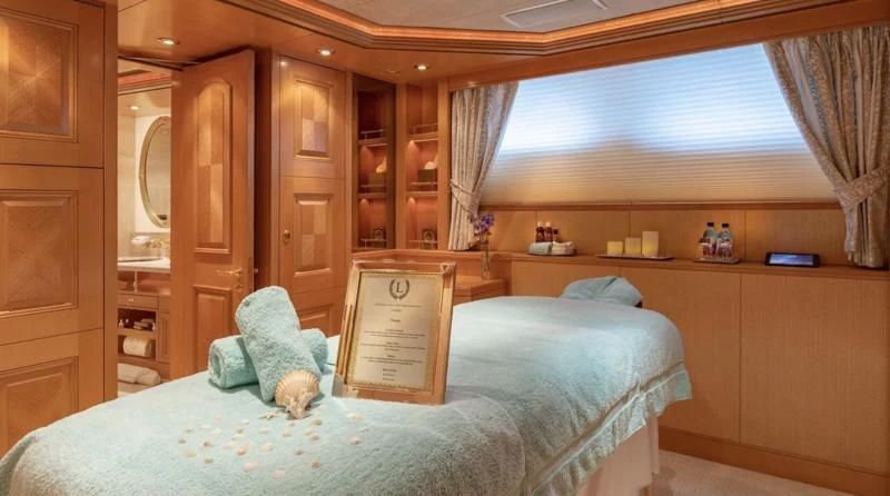 a bed with a blue blanket aboard LAUREL Yacht for Charter