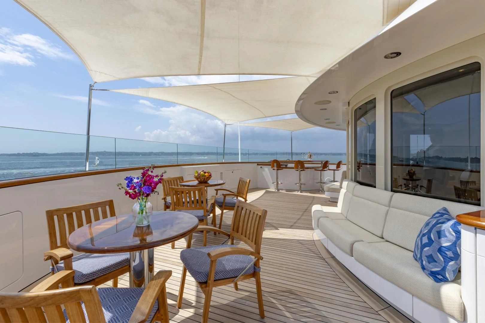 a large white tent with tables and chairs and a white couch aboard LAUREL Yacht for Charter