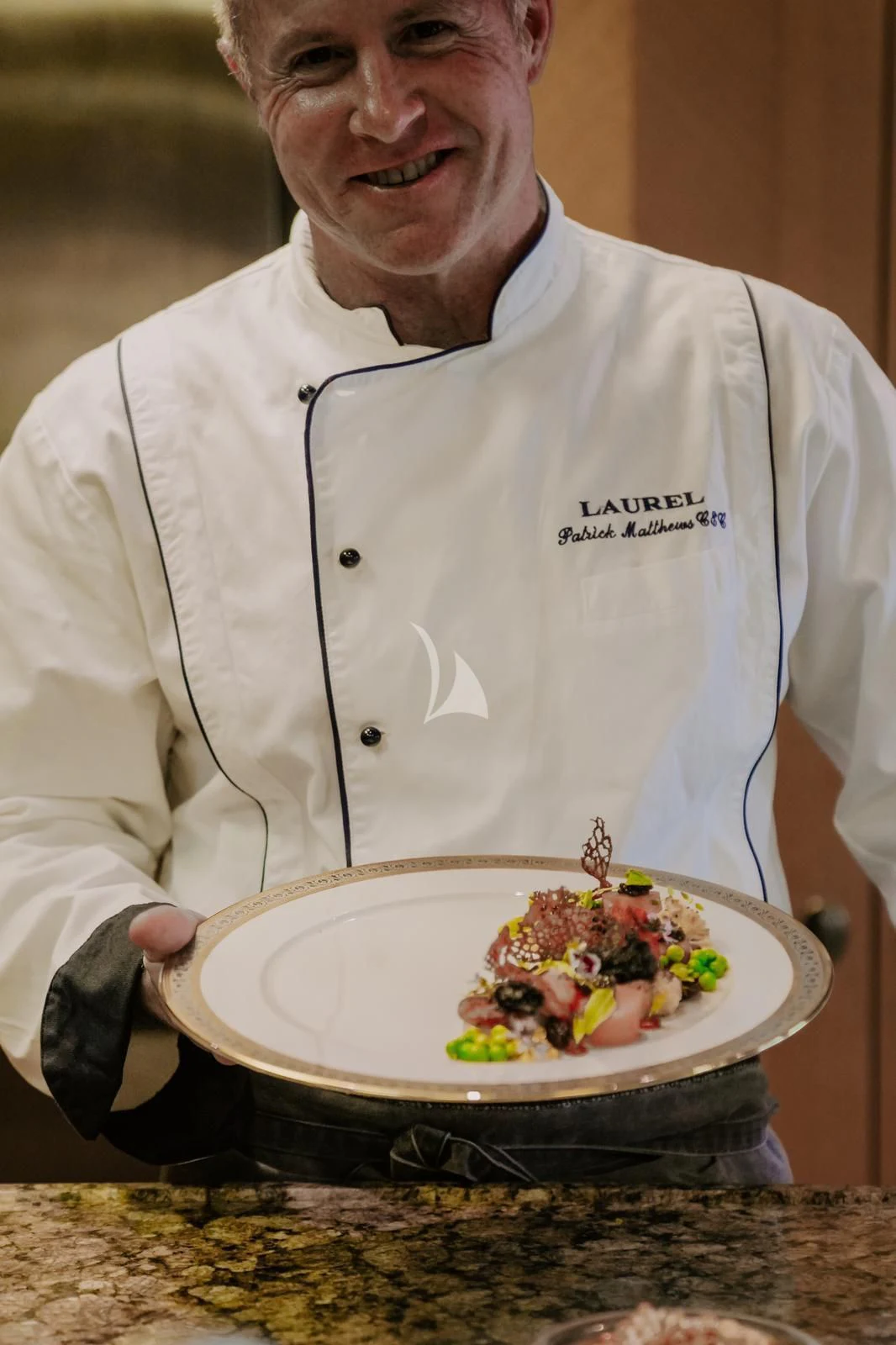 a man holding a plate of food aboard LAUREL Yacht for Charter