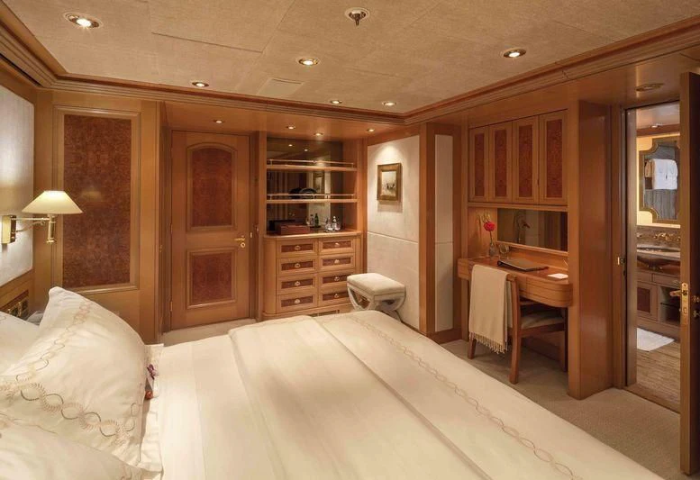a bedroom with a bed and desk aboard LAUREL Yacht for Charter