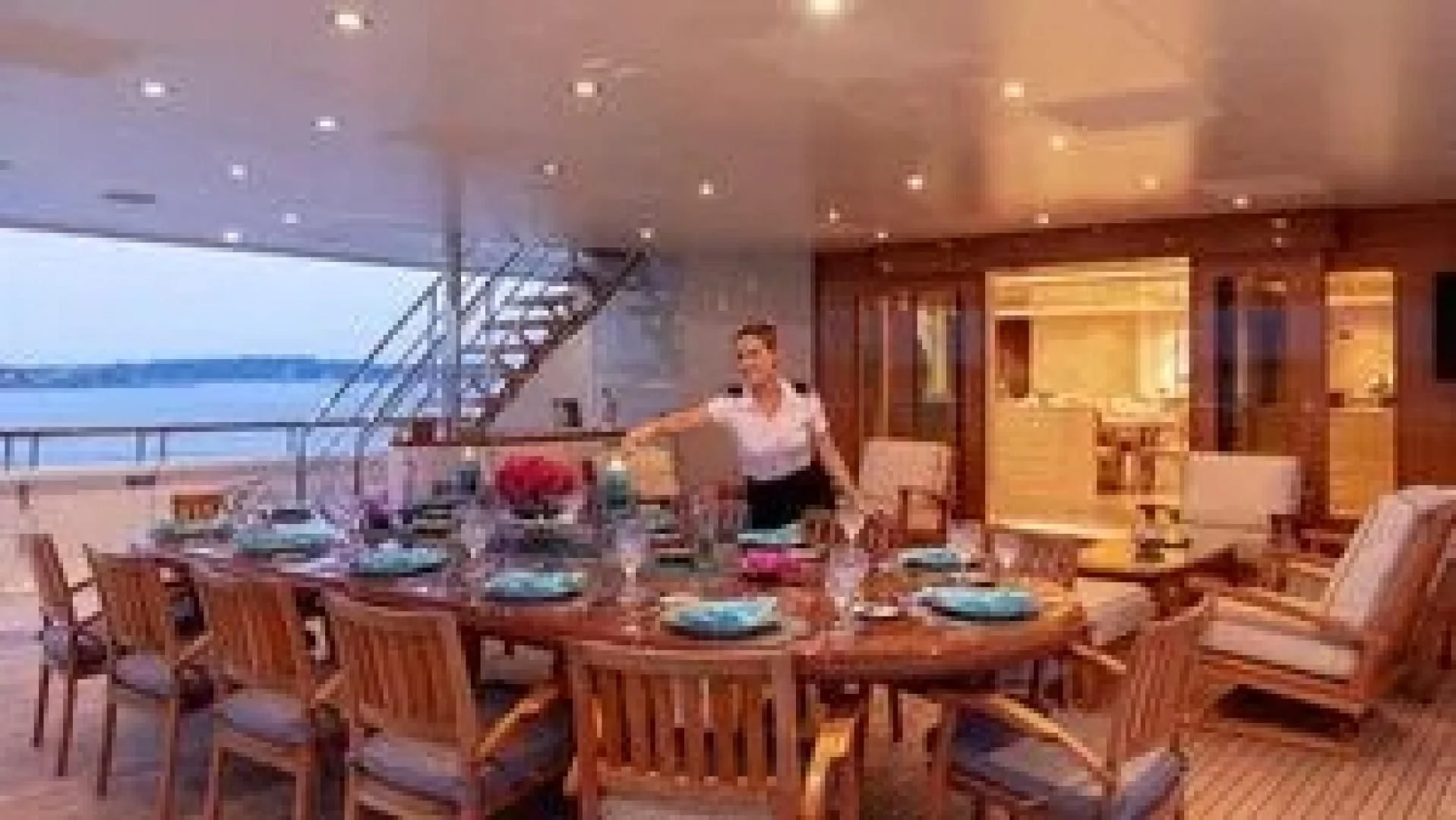a person standing behind a table with wine glasses on it aboard LAUREL Yacht for Charter