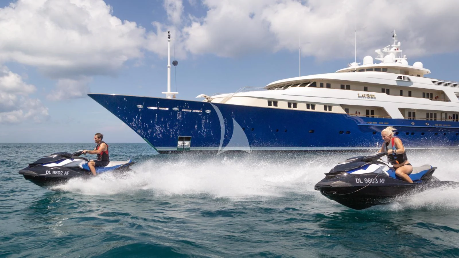 a couple of people on a boat in the water by a large cruise ship aboard LAUREL Yacht for Charter