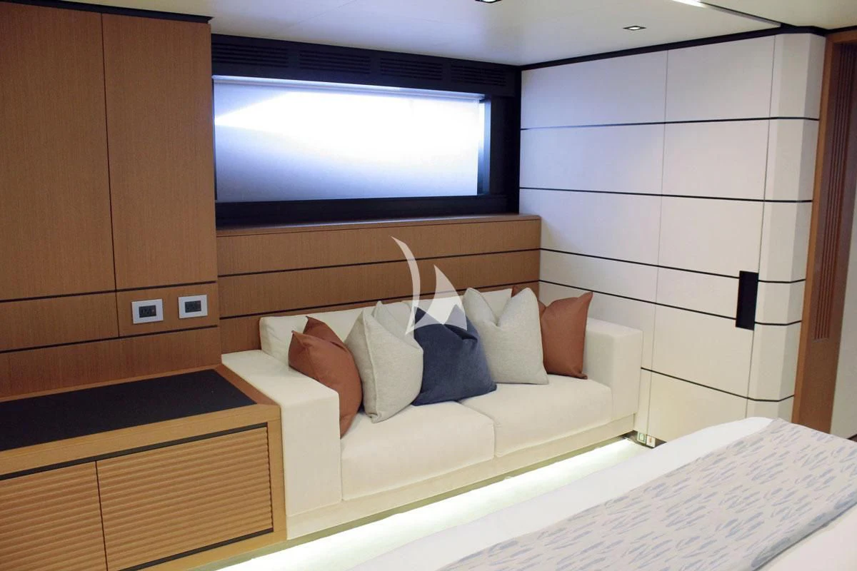 a bed with pillows and a television in the background aboard BAD MUTHA Yacht for Sale
