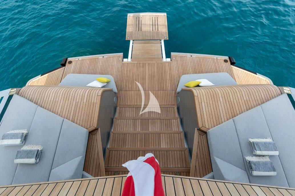 a boat with a deck and a deck and a deck with chairs and a table and a laptop aboard BAD MUTHA Yacht for Sale