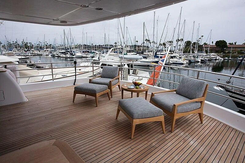 a deck with a table chairs and a view of a marina aboard LACEY KAY Yacht for Sale