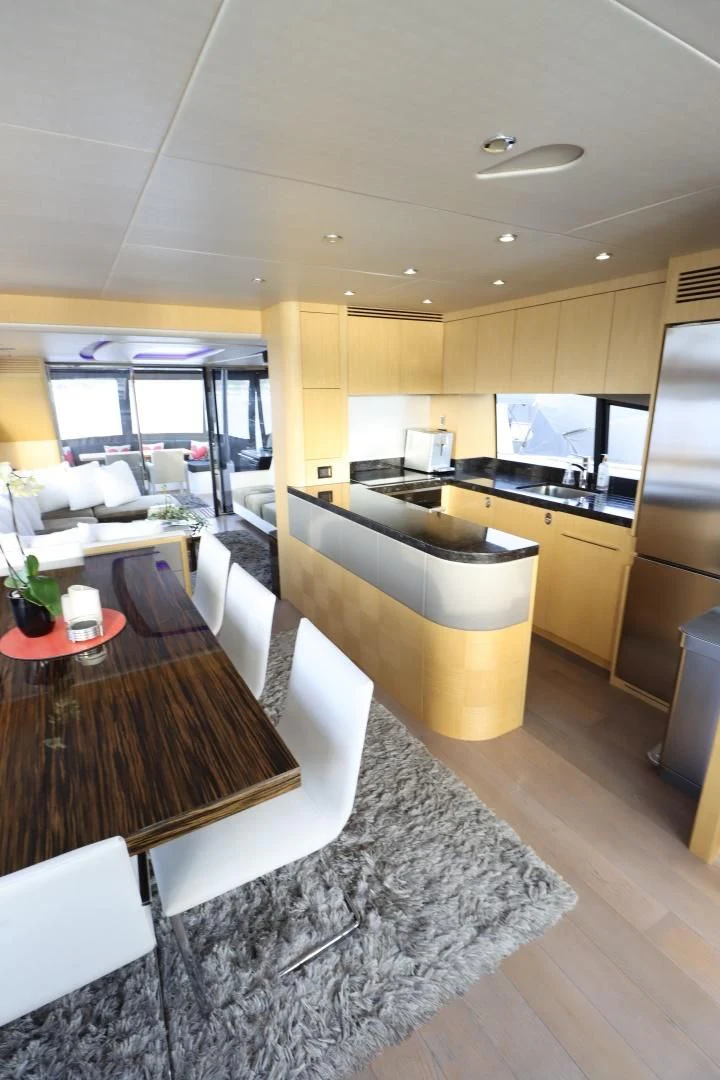 a kitchen with a table and a tv aboard MOJO RISIN Yacht for Sale
