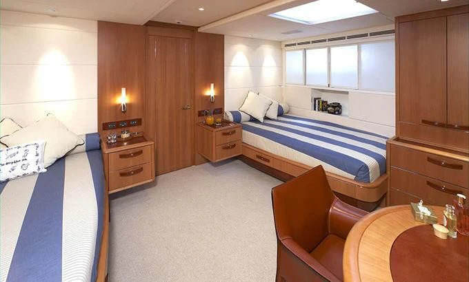 a bedroom with a bed and a chair aboard SWAGGER Yacht for Sale