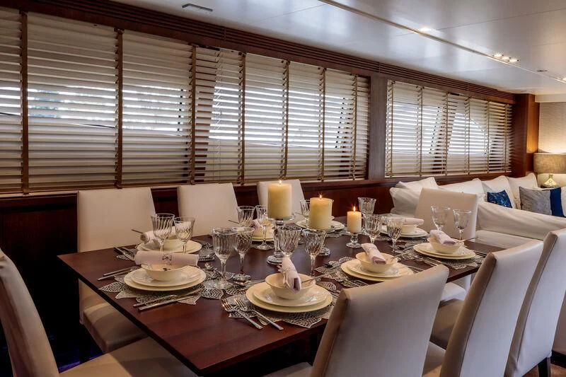 a table set with plates and candles aboard MIRAVAL Yacht for Charter