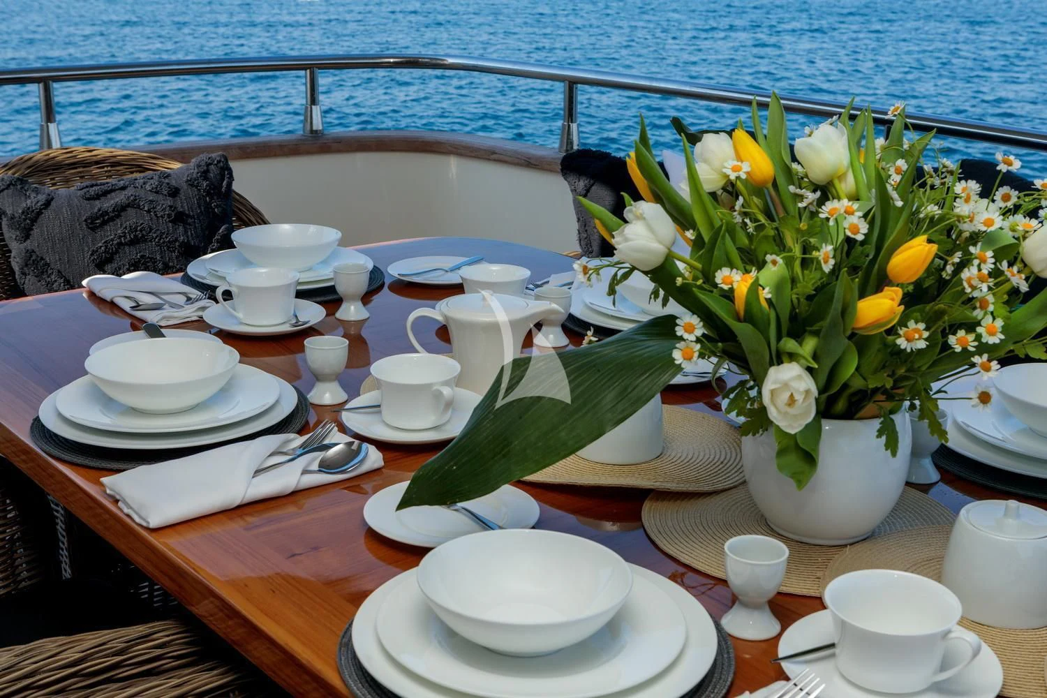 a table with plates and cups aboard MIRAVAL Yacht for Charter
