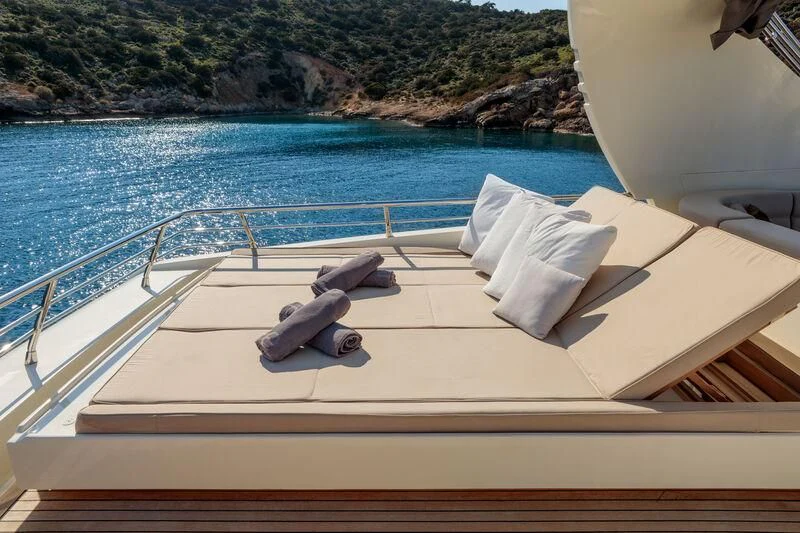 a deck with a view of the ocean and the mountains aboard MIRAVAL Yacht for Charter