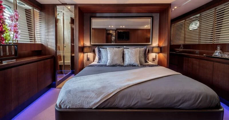 a bed with a blue sheet aboard MIRAVAL Yacht for Charter