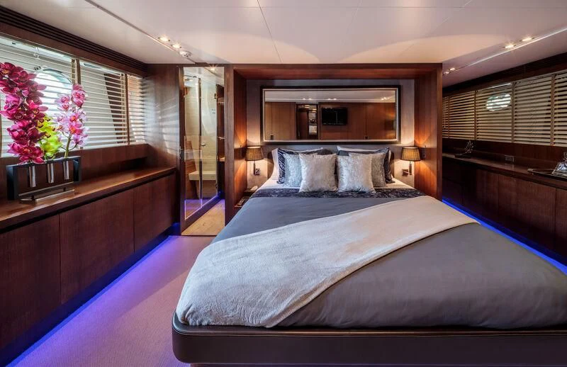 a bed with a blue comforter aboard MIRAVAL Yacht for Charter