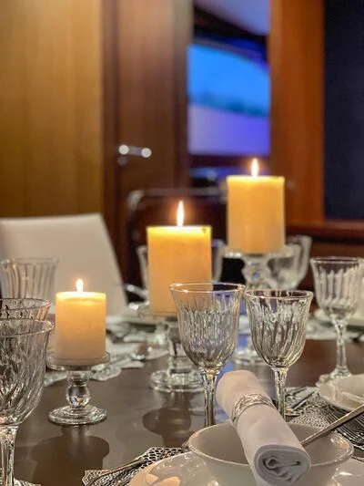 a table with wine glasses and candles aboard MIRAVAL Yacht for Charter
