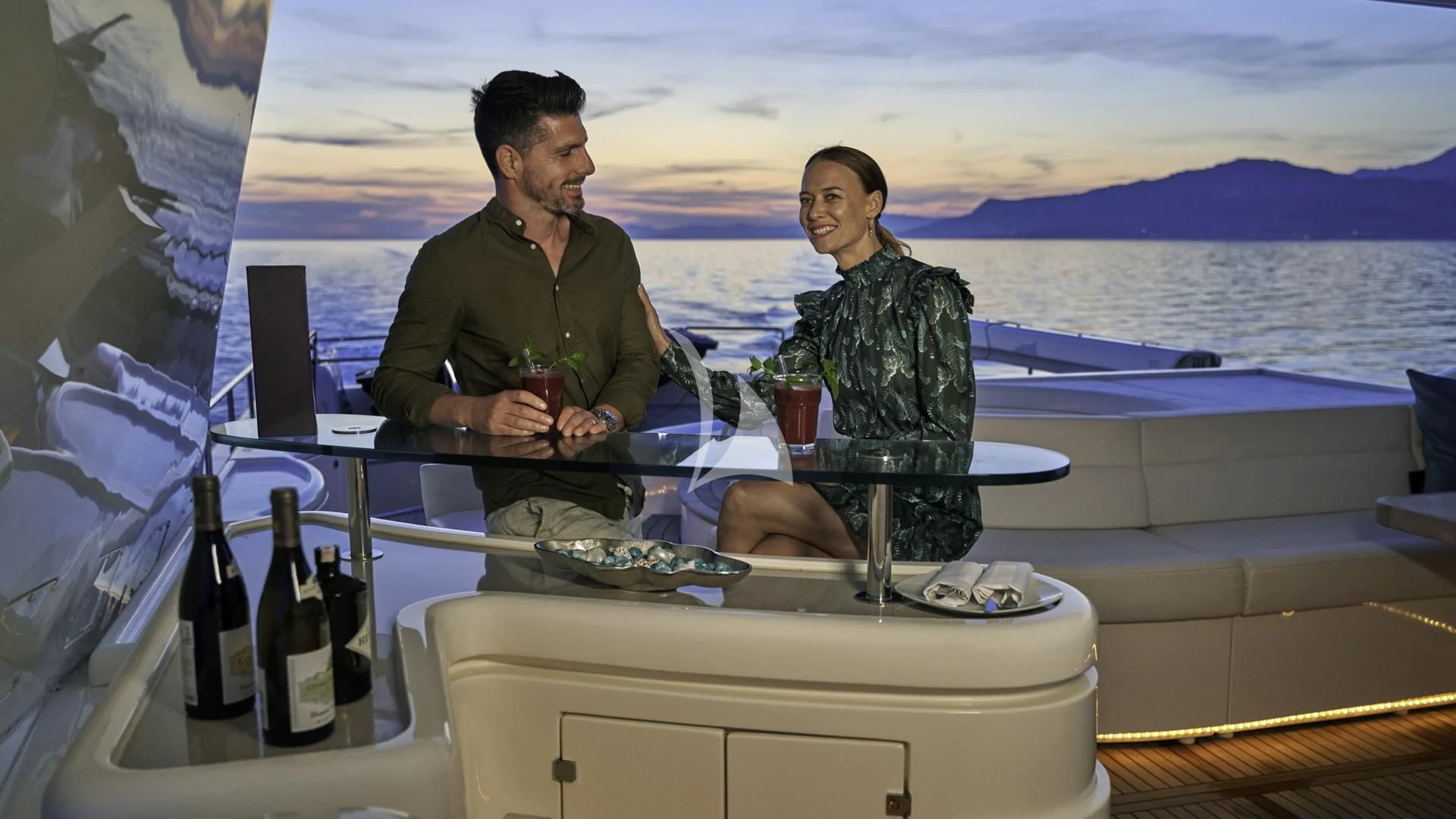 a couple of men sitting on a boat with wine bottles aboard ACCEPTUS Yacht for Sale