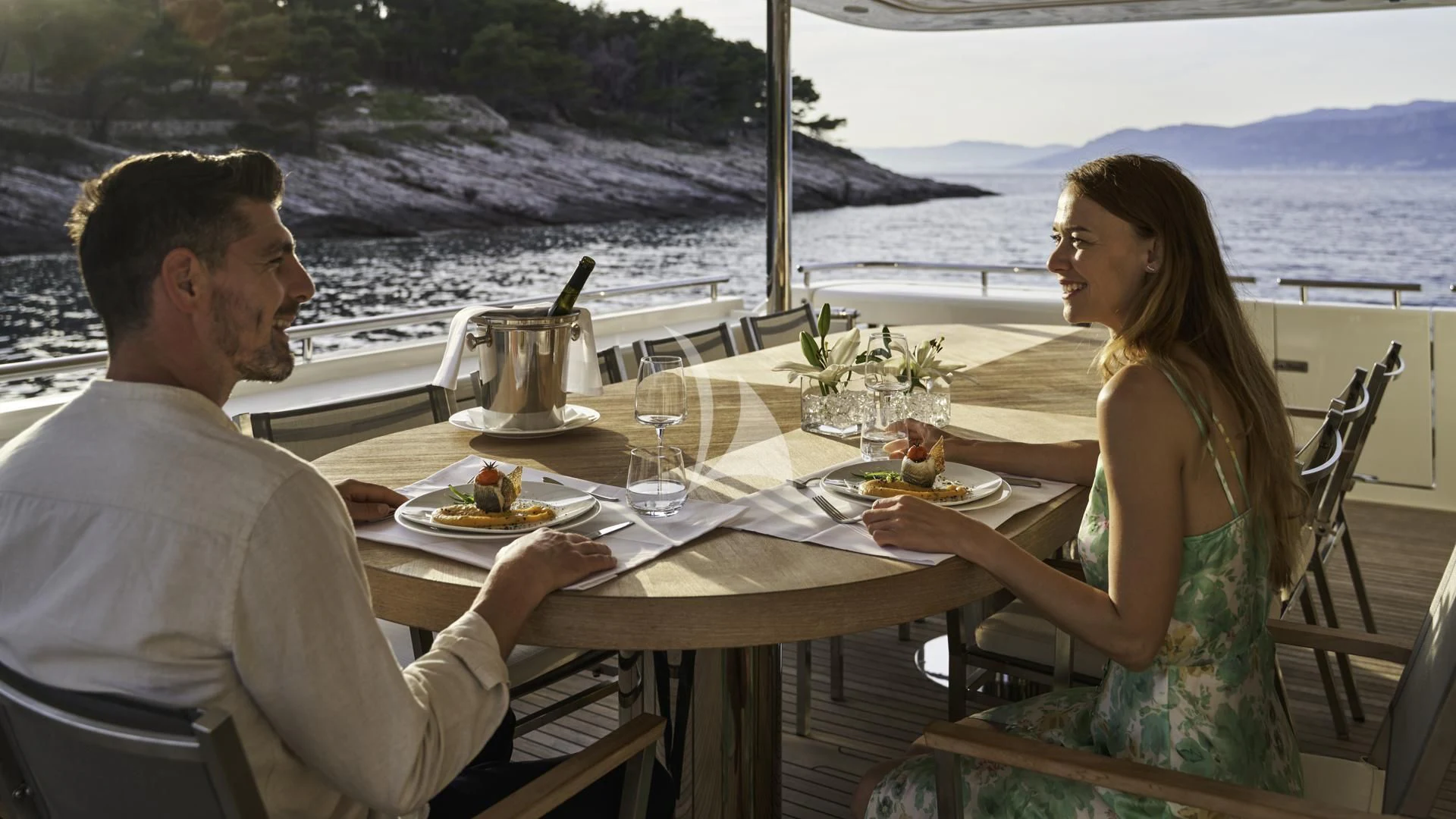 a man and woman sitting at a table with food on it aboard ACCEPTUS Yacht for Sale
