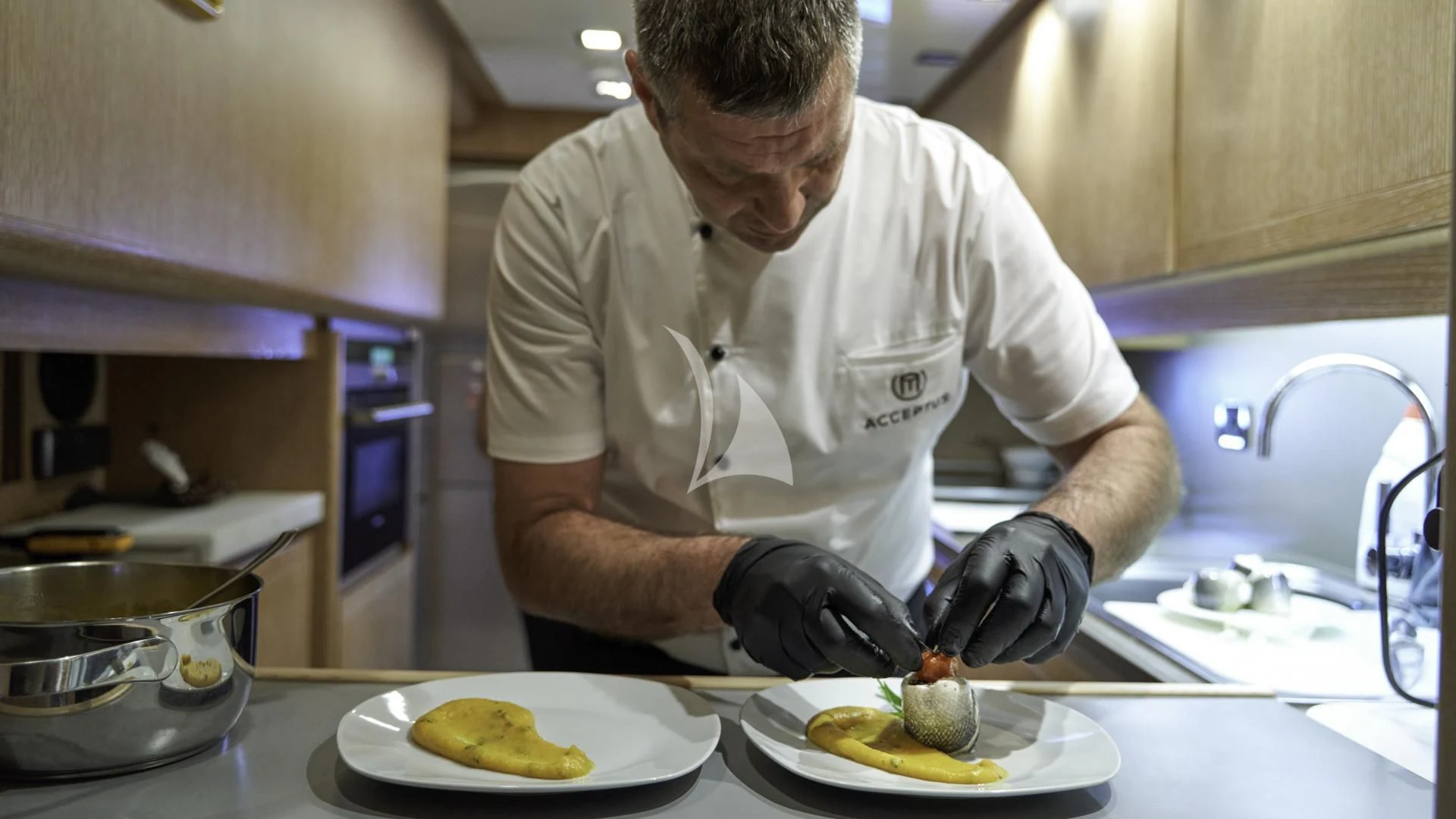a man in a kitchen preparing food aboard ACCEPTUS Yacht for Sale
