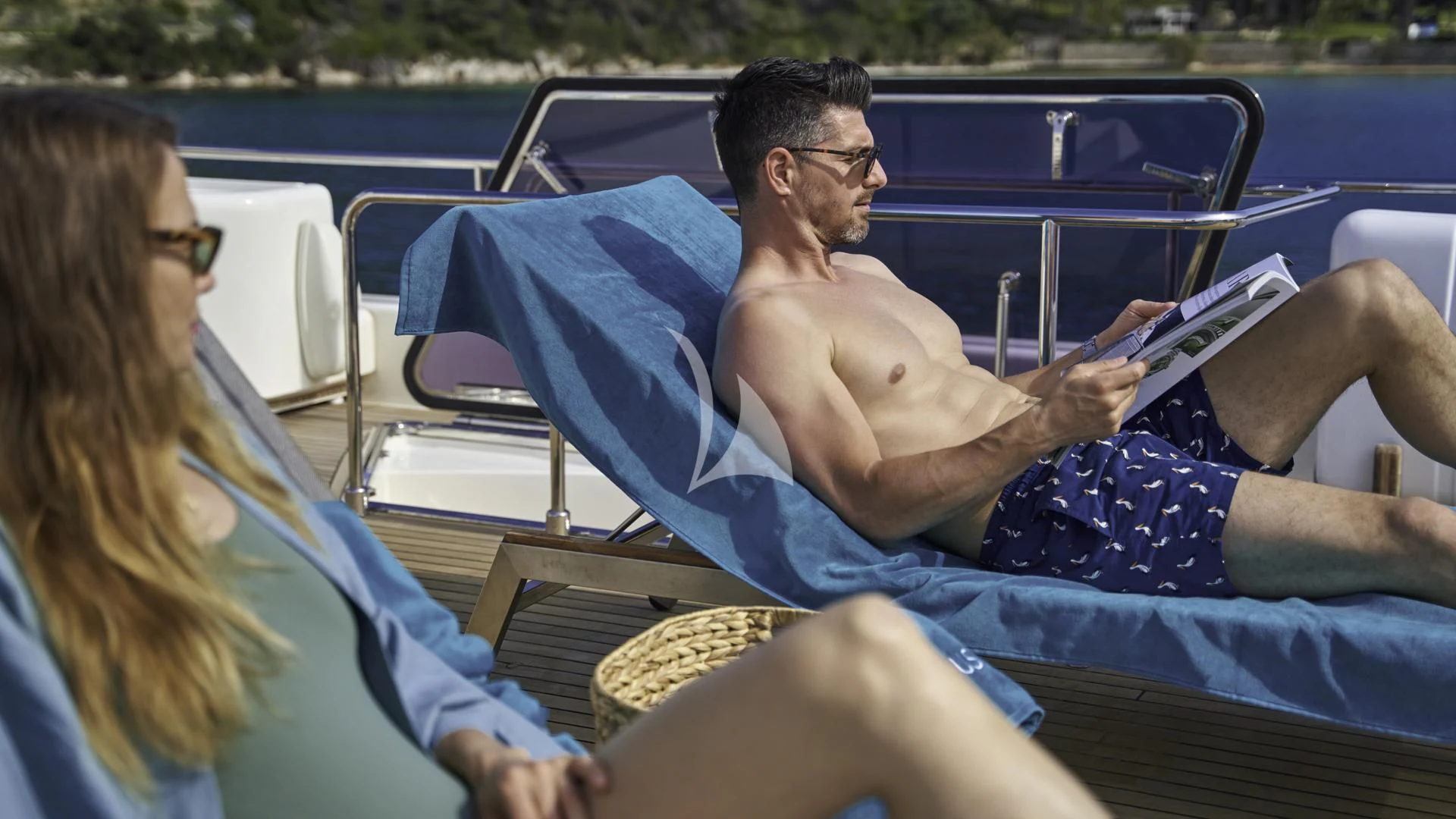 a man and woman sitting in a blue convertible car aboard ACCEPTUS Yacht for Sale