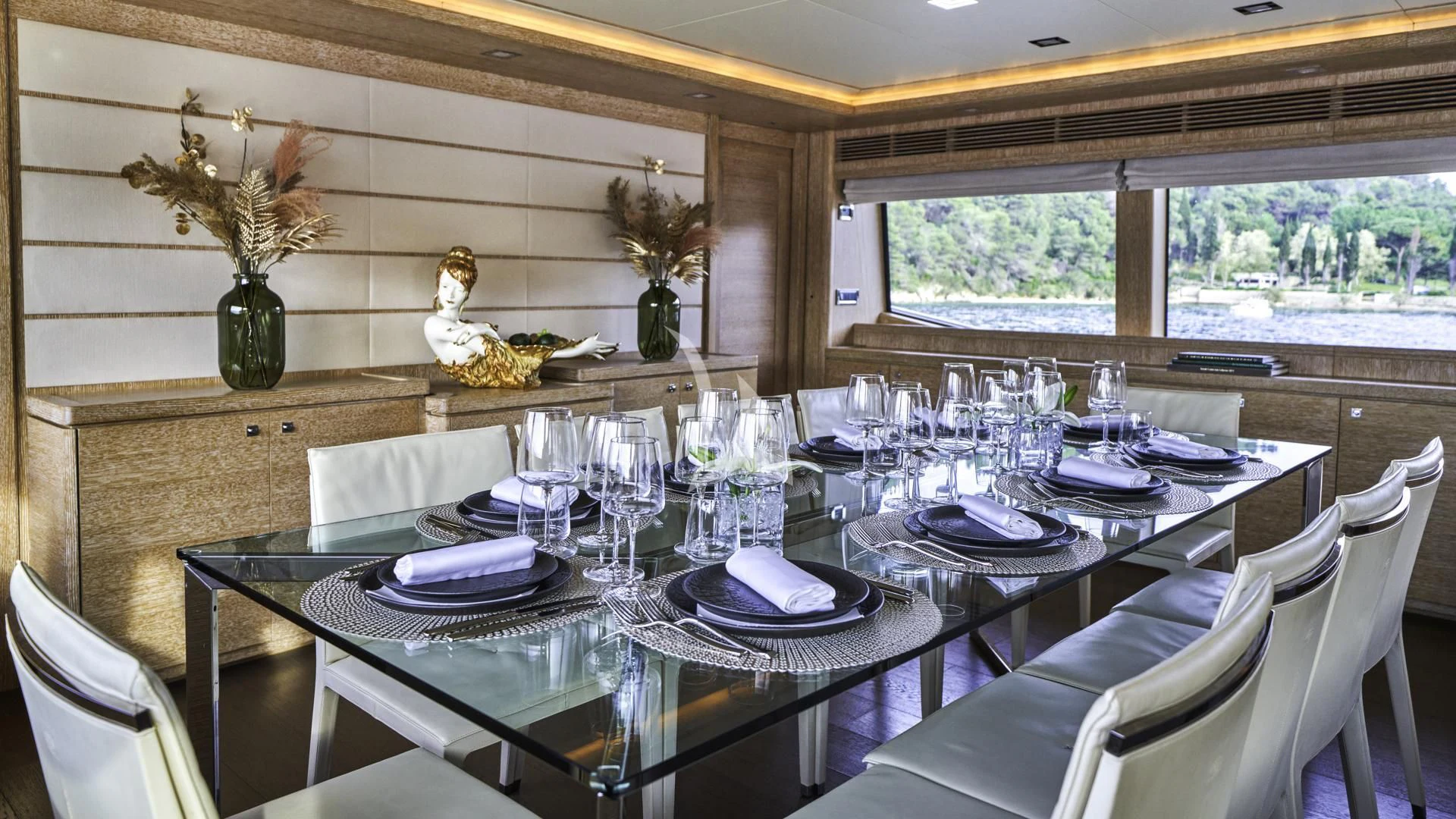 a dining table with a vase of flowers and a plant on the table aboard ACCEPTUS Yacht for Sale