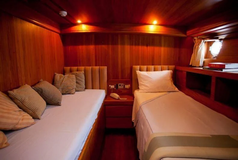 a room with beds and a window aboard TAMARIND Yacht for Sale