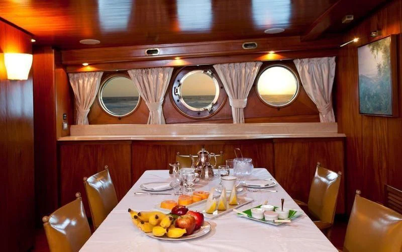 a dining table with plates and glasses aboard TAMARIND Yacht for Sale