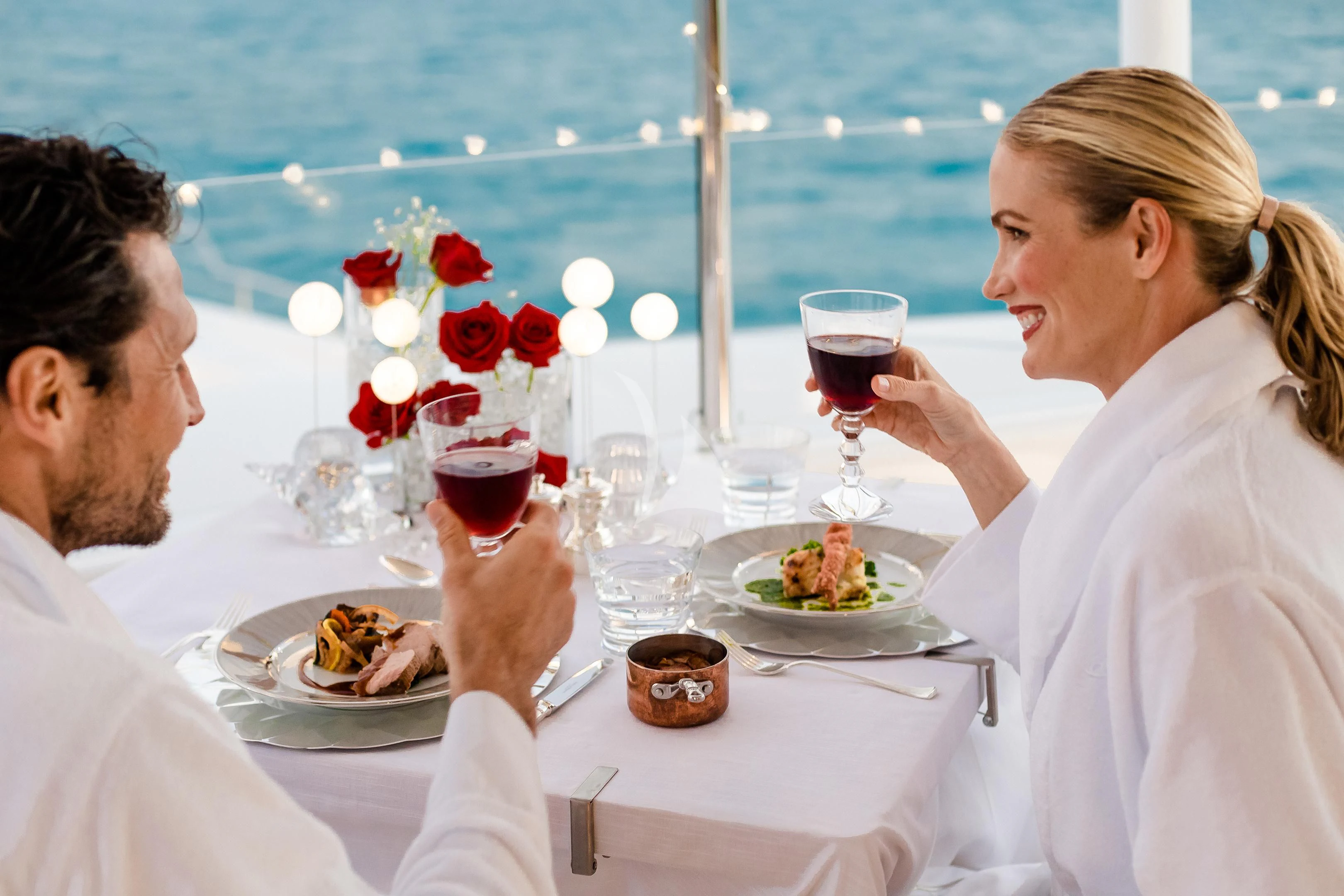 a group of people sitting at a table with food and drinks aboard STARBURST IV Yacht for Charter