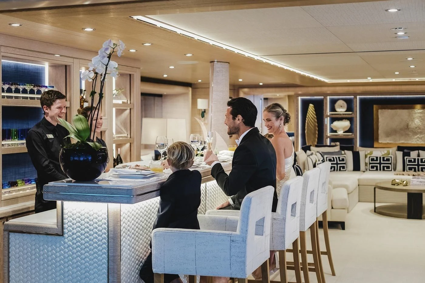 a group of people sitting at a table in a room with a statue aboard STARBURST IV Yacht for Charter