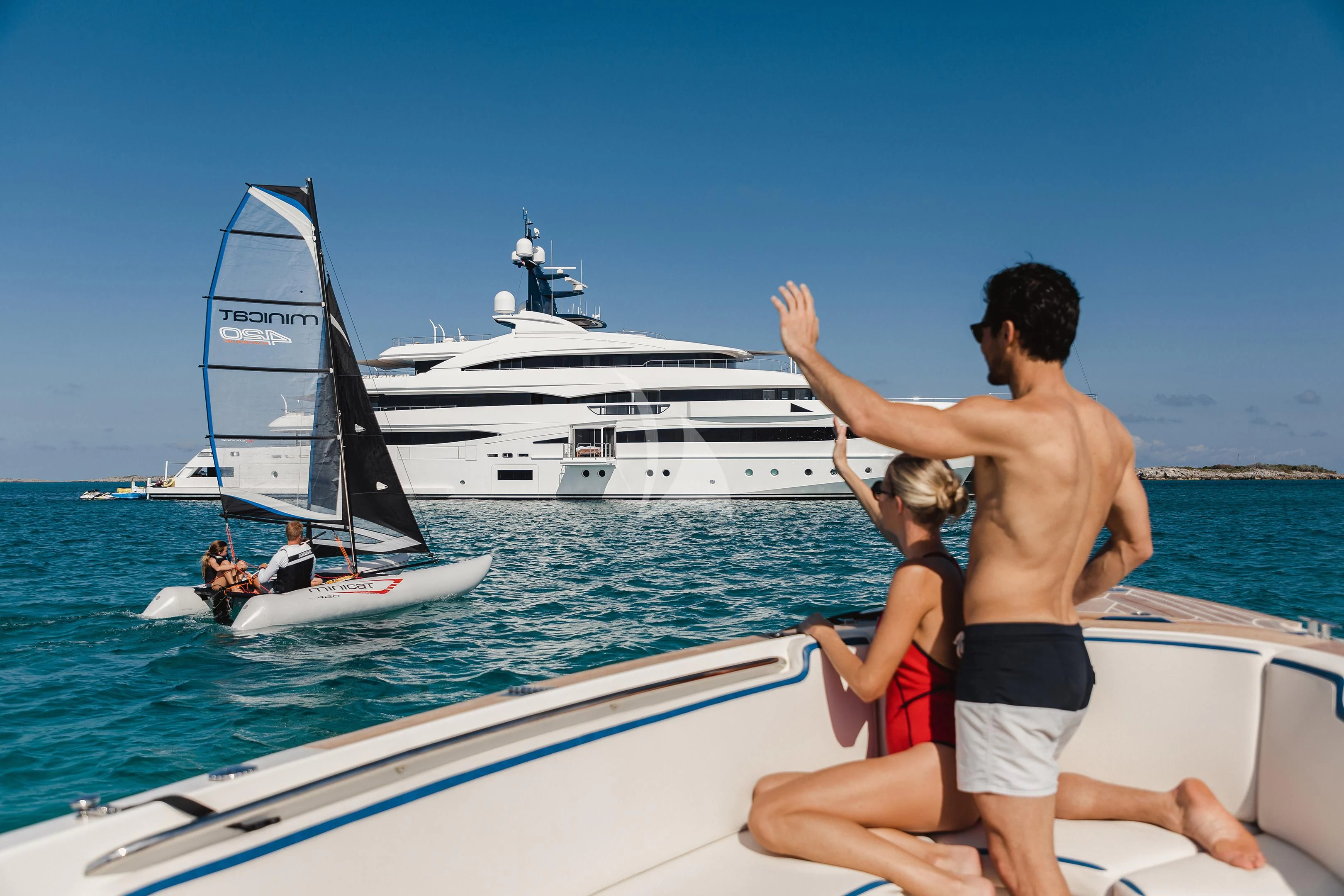 a man and a woman on a boat with a large white boat in the background aboard STARBURST IV Yacht for Charter