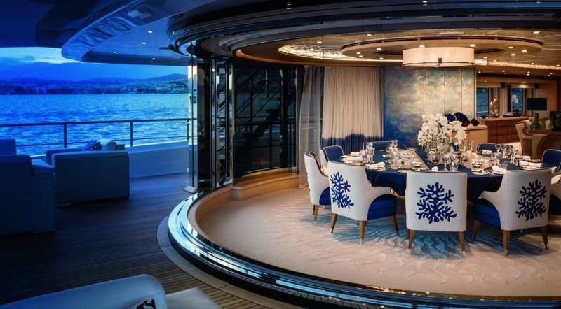 a room with a large table and chairs and a large body of water aboard STARBURST IV Yacht for Charter