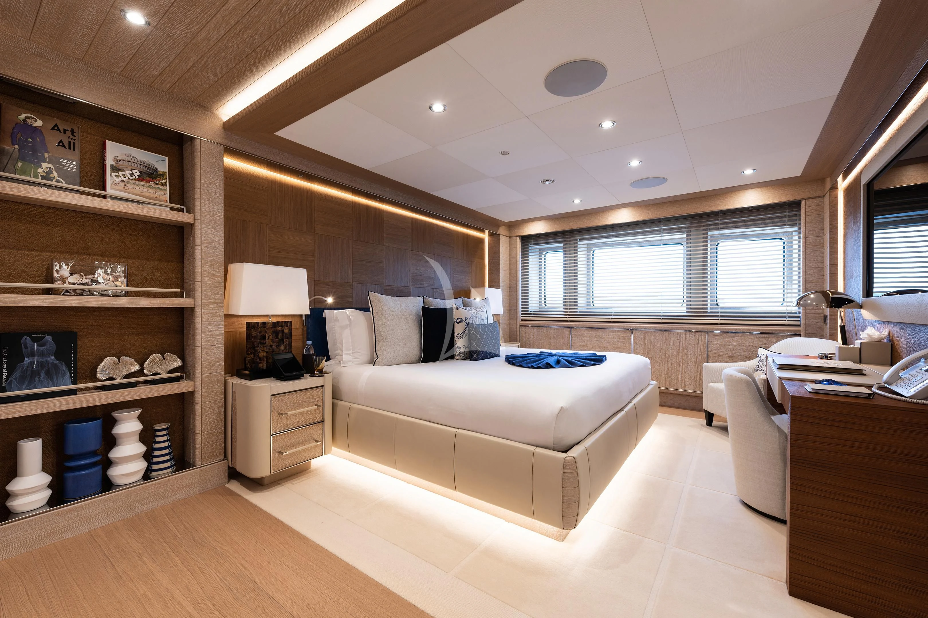 a room with a bed and a shelf with books on it aboard STARBURST IV Yacht for Charter