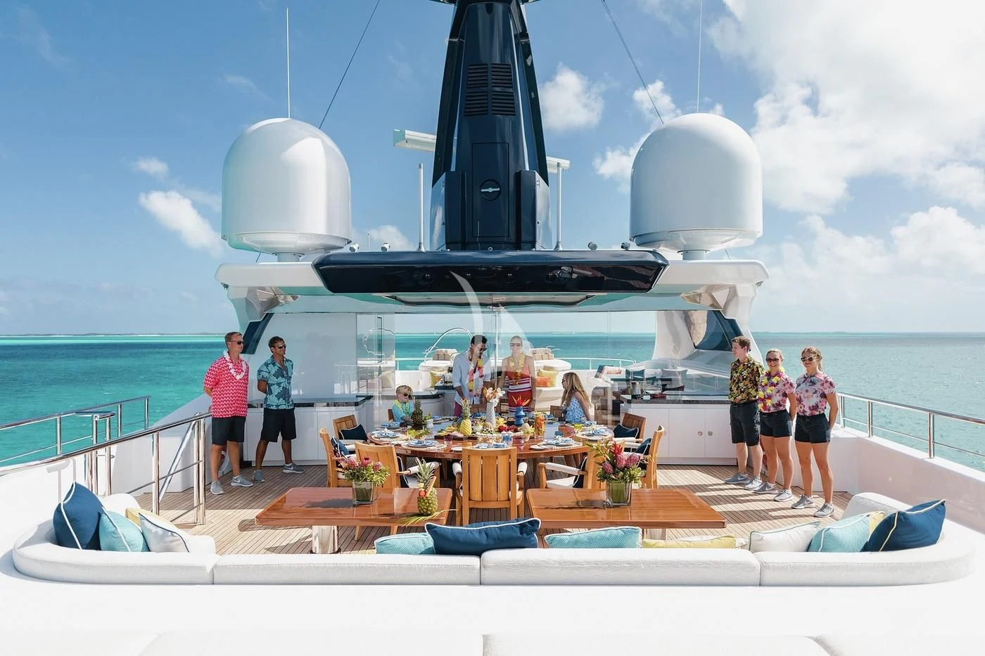 a group of people standing on a deck in front of a large ship aboard STARBURST IV Yacht for Charter