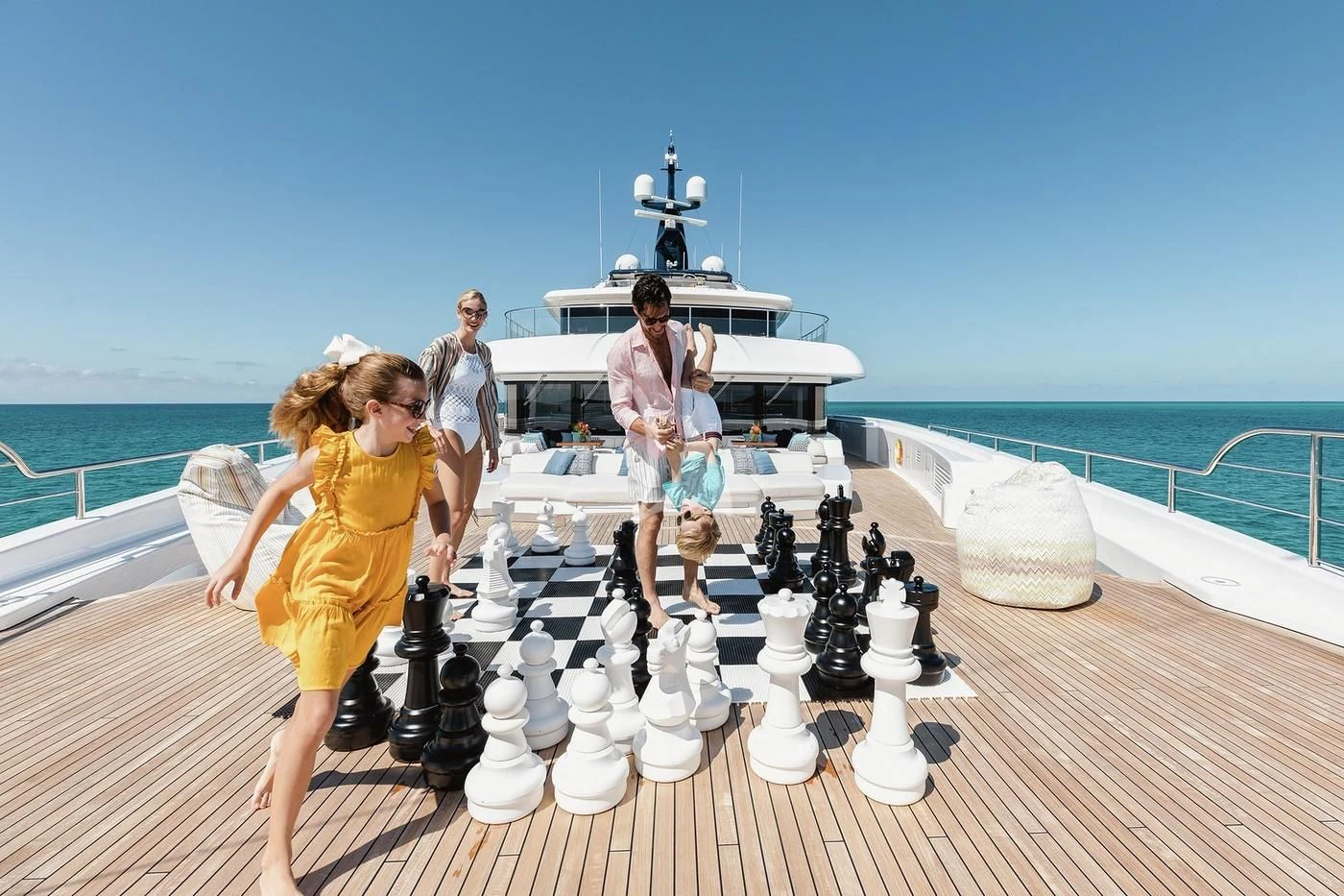 a group of people playing chess on a deck by the ocean aboard STARBURST IV Yacht for Charter