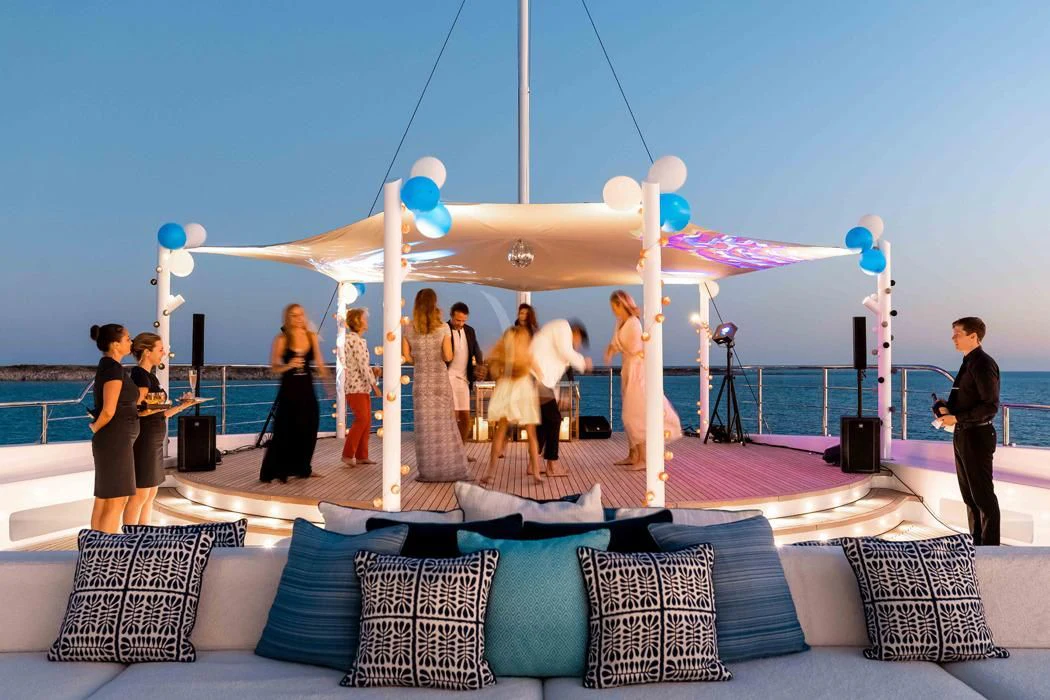 a group of people standing on a stage with a large arch aboard STARBURST IV Yacht for Charter