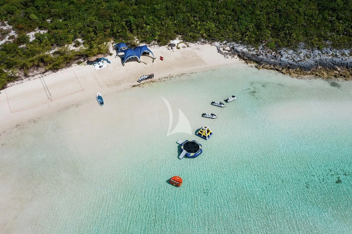 a beach with people and boats aboard STARBURST IV Yacht for Charter