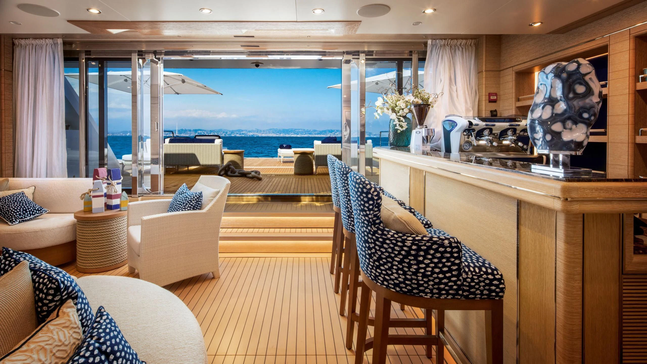 a room with a table chairs and a view of the ocean aboard STARBURST IV Yacht for Charter
